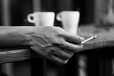 Close-up of hand holding cigarette