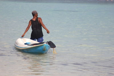 Rear view of man rowing boat in sea