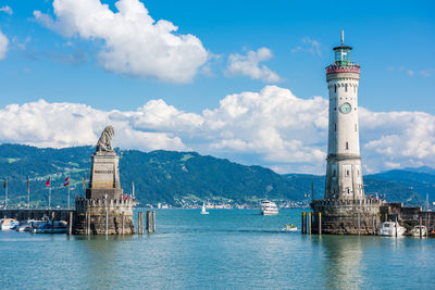 Lighthouse by sea against sky