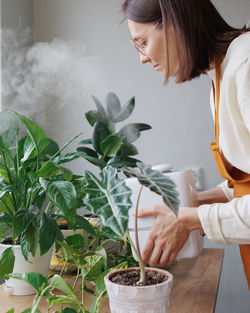 Young woman holding potted plant