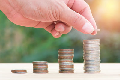 Cropped hand stacking coins on table