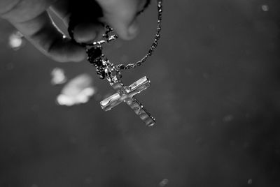 Close-up of hand holding rosary beads