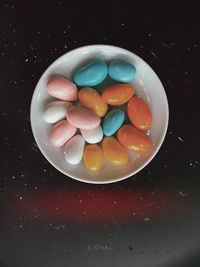 Directly above shot of multi colored candies in bowl on table