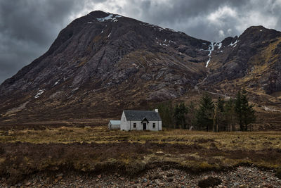 House on mountain against sky