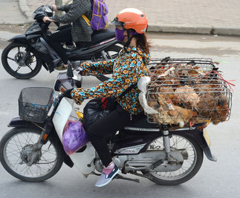 Rear view of people riding bicycle