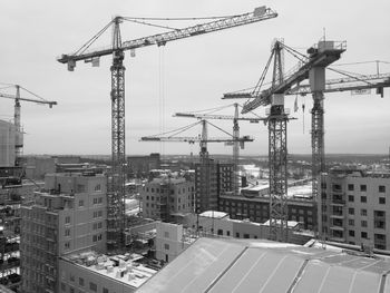 Cranes at construction site against sky