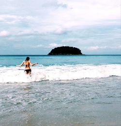 Woman on beach against sky