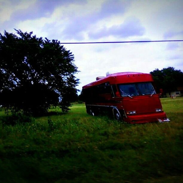 transportation, sky, tree, mode of transport, grass, land vehicle, field, cloud - sky, car, growth, green color, cloud, nature, landscape, outdoors, grassy, day, travel, cloudy, plant