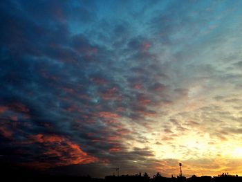 Silhouette of trees against cloudy sky