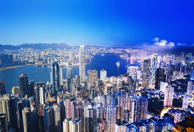 Aerial view of city and buildings against blue sky