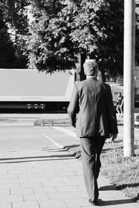 Rear view of man walking on tree