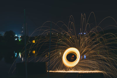 Illuminated wire wool against sky at night