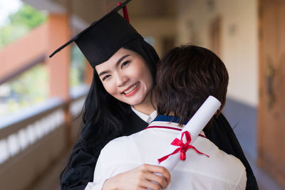 Portrait of smiling young woman holding umbrella