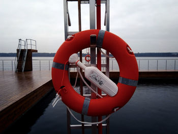 Life belt at poolside on boat in sea against sky