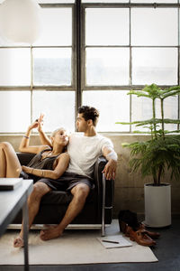 Romantic couple talking while resting on sofa at home