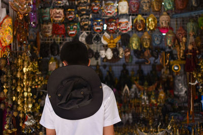 Rear view of boy standing at market