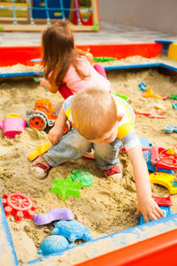 High angle view of siblings playing with toy