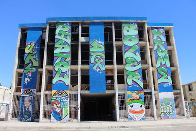 Low angle view of multi colored building against blue sky