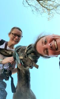 Portrait of smiling women taking selfie with donkey
