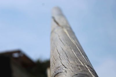 Low angle view of wooden post against sky