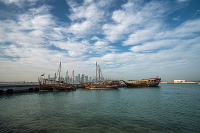 Sailboats in sea against sky