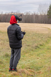 Young man launches rc plane into sky. teenager with glasses playing with toy radio-controlled