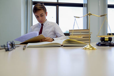 Lawyer reading document at desk in office