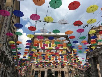 Low angle view of lanterns hanging by building against sky