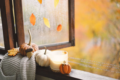 Still life details in home on a wooden window. sweater, candle, hot tea and autumn decor