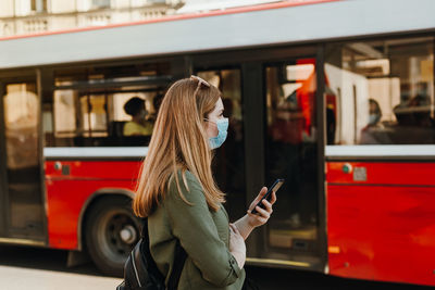 Midsection of woman using mobile phone while sitting in bus