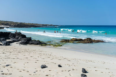 Scenic view of beach against clear blue sky