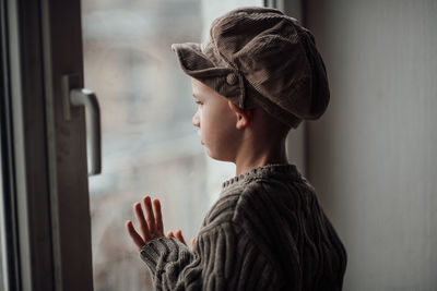 Side view of boy looking at window