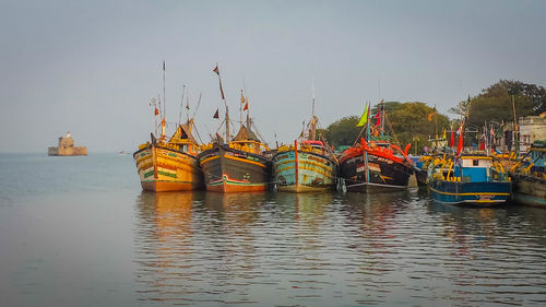 Boats moored in river against clear sky