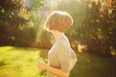 Rear view of boy standing on grass