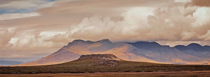 Scenic view of mountains against cloudy sky