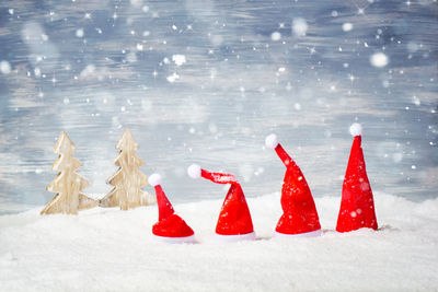 Santa hats on artificial snow against backdrop
