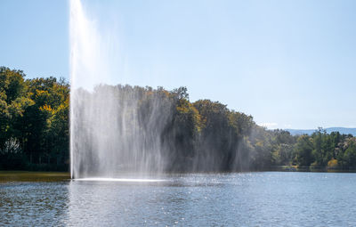 Fountain spraying water against the background of forest