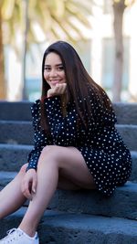 Portrait of a smiling young woman sitting outdoors