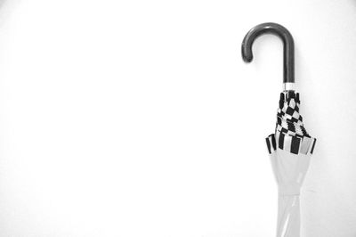 Close-up of rolled umbrella against white background