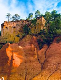 Rock formations on landscape against cloudy sky