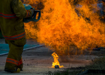 Midsection of man extinguishing fire