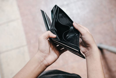 Midsection of person holding hands against wall