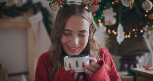 Portrait of young woman using mobile phone at home