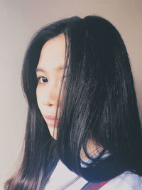 Close-up portrait of woman against white background