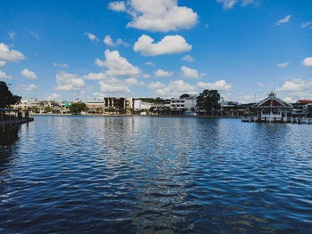 Scenic view of river by buildings against sky