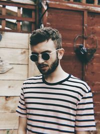 Portrait of young man wearing sunglasses standing outdoors