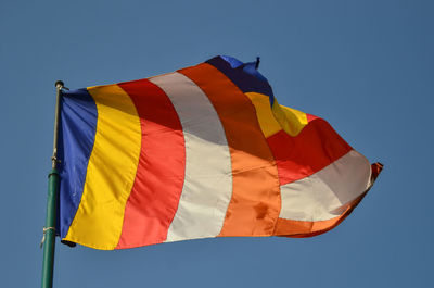 Low angle view of flag against blue sky