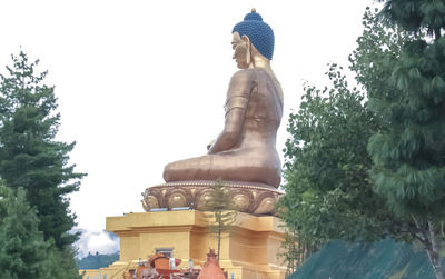 Statue of buddha against trees