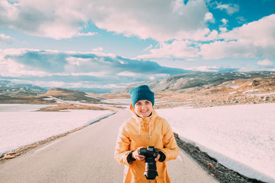 Portrait of young woman standing on road