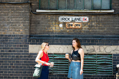 Full length of a woman standing against the wall